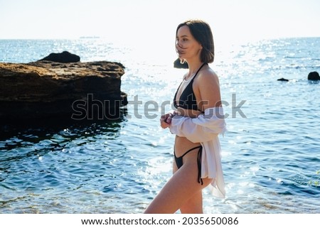 Young woman portrait on the sea background. Joyful girl walking on the beach