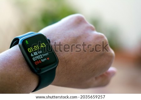 Anonymous Man Using A Digital Smartwatch During Workout.
Closeup View Of Man's Hands Checking An App In Smartwatch. Close-up Of A Clock That Shows Steps, Kilometers And bpm.