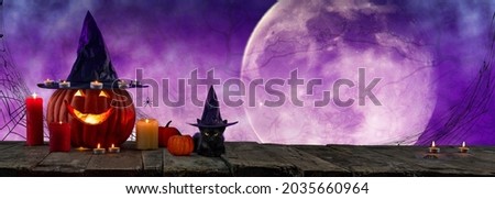 Halloween party. Black cat and carved pumpkin lantern jack wearing witch's hat among candles and night lights. Banner layout with copy space empty background for design cards, posters, invitations