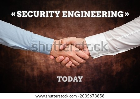Conceptual caption Security Engineering. Conceptual photo focus on the security aspects in the design of systems Two Professional Well-Dressed Corporate Businessmen Handshake Indoors
