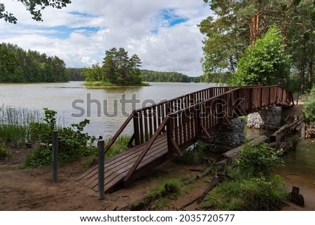 Bridge over stream on forest lake Morozovsky, Vyaryamyanselkya ridge, Karelian Isthmus, Leningrad region, Russia. Royalty-Free Stock Photo #2035720577