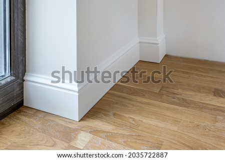 Detail of corner flooring with intricate crown molding and plinth.  Royalty-Free Stock Photo #2035722887