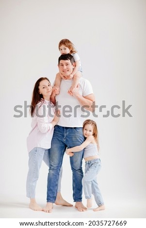 beautiful happy family in a white photo studio. Mom, dad and two daughters play and have fun. mortgage for a young family. parent-child relationship. a clothing store for the whole family. 
