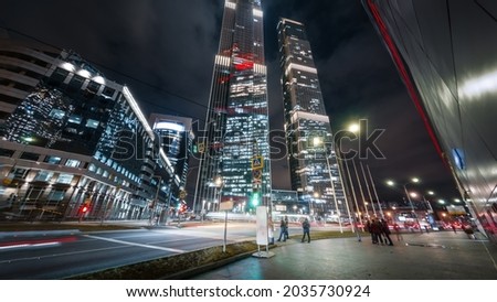 Beautiful big city busy street in the night. Modern skyscrapers glitter with neon lights, heavy traffic passing by and pedestrians crossing the intersection in the center of Moscow