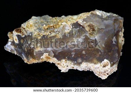 Chipped bluish-gray chalcedony on a black background close up, mineralogical sample. Deposit Russia Royalty-Free Stock Photo #2035739600