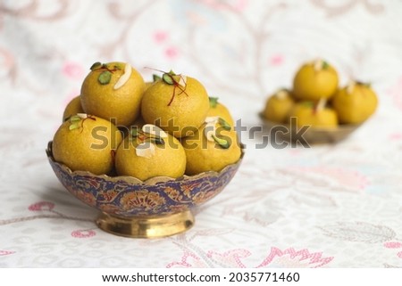 happy ganesh chaturthi, Besan laddu with dry fruits in a brass bowl on a floral background, landscape image, Royalty-Free Stock Photo #2035771460