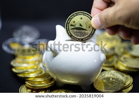 White piggy Bank on a black background and human hand putting coin in piggy bank for saving money wealth and finance concept and the copyspace for design.