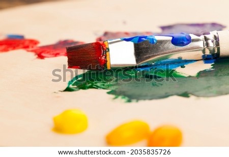oil and other paints with brushes for creativity, the creative process of drawing by mixing different colors of paints with art brushes, art brushes and paints for painting pictures