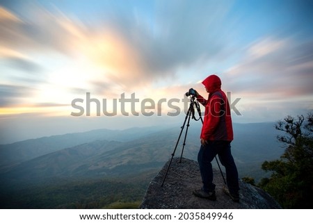 photographer taking a beautiful picture of landscape during sunset period on the view point