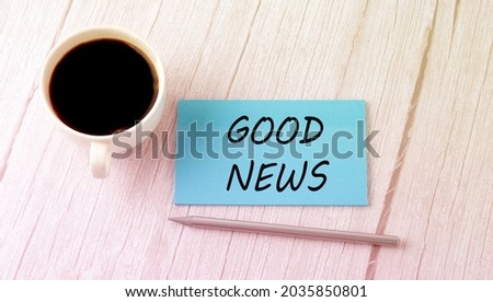 GOOD NEWS text on blue sticker with cofee and pen