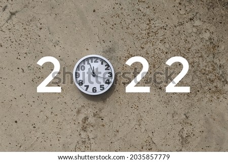 Happy New Year greeting card with large 2022 number and white wall clock. Year 2022 number.