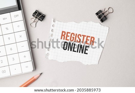 Business concept. Notebook with text Register online sheet of white paper for notes, calculator, glasses, pencil, pen, in the white background