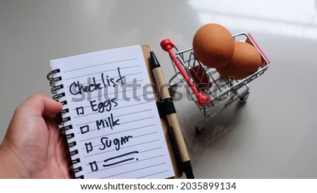 Checklist in the hands of a woman in a supermarket. shopping concept