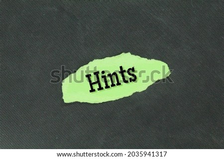 torn green paper with the word hints. Tips And Tricks