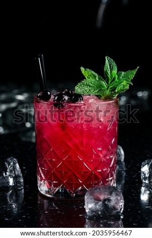 red bramble cocktail with berries and mint, Cocktail in a Glass, Blackberry, Blueberry, Ice and Mint Leaves, Vertical View Royalty-Free Stock Photo #2035956467