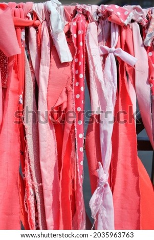 Bright red fabric hanging and swaying in the summer wind on a bright sunny day.