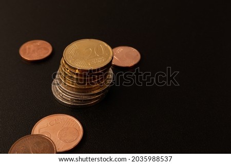 Euro coins of different denominations on a black table. Soft focus.