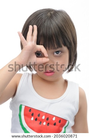 Happy kid on Halloween. A little cute  girl  with black eyeliner, look at the camera and make a hand sign to show it's OK. on white background.