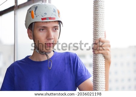 The guy in the white helmet. A construction worker and a blue T-shirt on the background of an urban landscape on an autumn evening.
