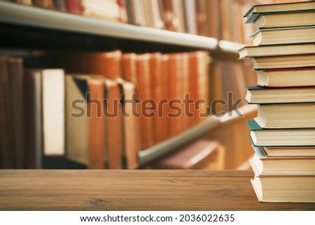 Many books on wooden table in library. Space for text 