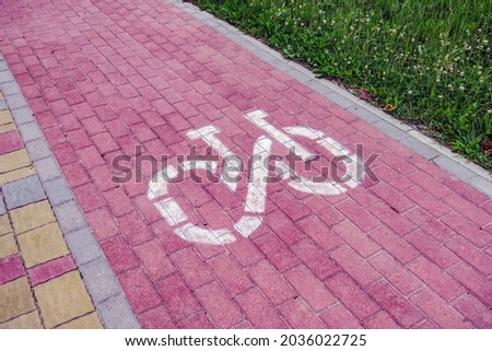 Red and gray cobblestones on which the sign of a bicycle path is drawn