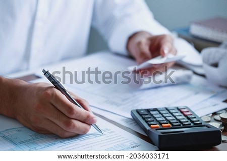 Man hand filling US tax form. tax form us business income office Financial document. Tax time.Tax concept. Close-up. Royalty-Free Stock Photo #2036033171