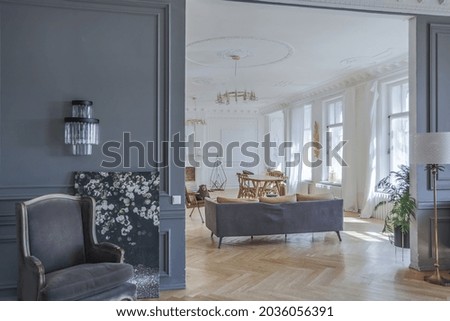 luxury interior of a spacious apartment in an old 19th century historical house with modern furniture. high ceiling and walls are decorated with stucco Royalty-Free Stock Photo #2036056391