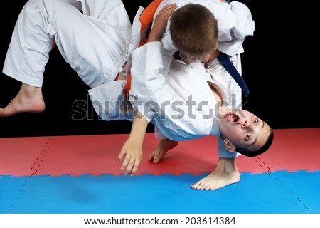 On the red and blue mat athletes are doing throws Royalty-Free Stock Photo #203614384