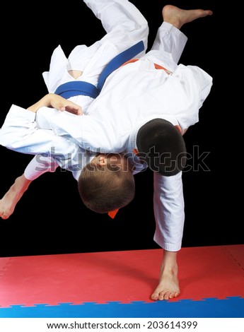 Very high throw in performing sportsman with orange belt Royalty-Free Stock Photo #203614399