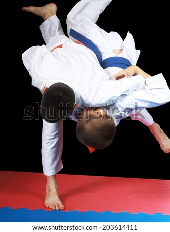 Beautiful high throw are doing  sportsmen in judogi Royalty-Free Stock Photo #203614411
