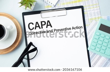 Paper with text CAPA Corrective And Preventive Action on a table