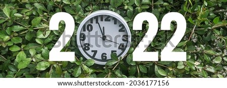 Happy New Year greeting card with large 2022 number and white wall clock. Year 2022 number.