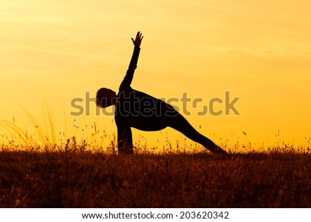A silhouette of a woman practicing yoga,Yoga-Virabhadrasana /Rotated warrior pose
