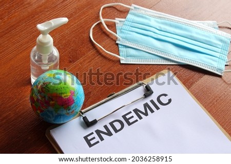 Medical and healthcare concept. Facemask, hand sanitizer, earth globe and paper clipboard with text ENDEMIC Royalty-Free Stock Photo #2036258915