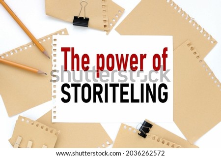 THE POWER OF STORYTELLING, business concept, text on white notepad paper. on a white photo with torn paper