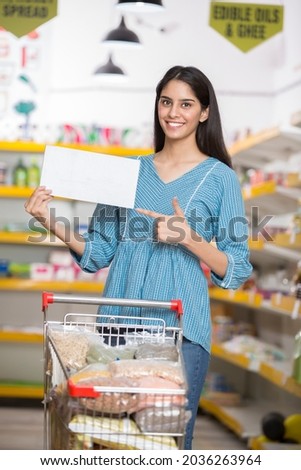 Smiling woman holding a blank sign with supermarket