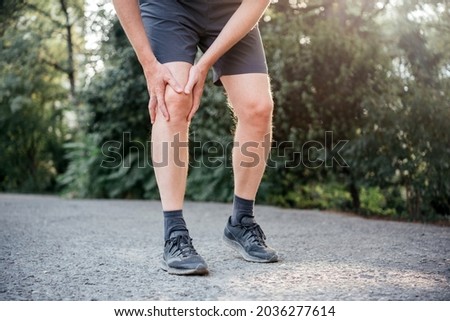 A man having difficulty in straightening or bending the knee because of bursitis Royalty-Free Stock Photo #2036277614