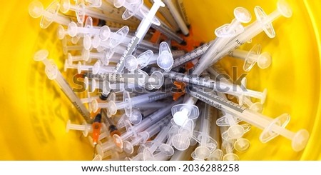 close up of the used vaccine needles in the sharp bin.  Royalty-Free Stock Photo #2036288258