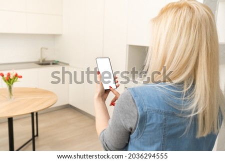 Woman using smartohone in smart house, empty screen Royalty-Free Stock Photo #2036294555