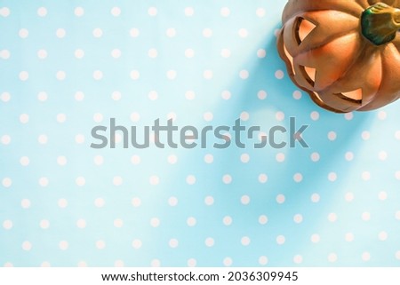 Cute Halloween little pumpkin on a light blue with white polka dot background