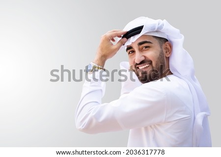 Young handsome Emirati businessman in UAE traditional outfit showing a variety of hand gesture. Arabic ambitious mature businessman. Royalty-Free Stock Photo #2036317778
