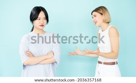 Right proving. Quarrel women. Disagreement arguments. Conflict explanation. Apologizing caucasian lady talking with asian suspicious friend isolated blue. Royalty-Free Stock Photo #2036357168