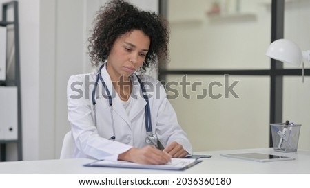 Female African Doctor Writing on Paper