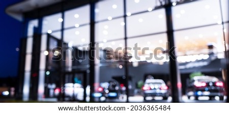 Blurred background with car dealership exterior. Abstract blurred photo of modern building motor showroom. Blur car show room office bokeh lights. Automobile retail shop Royalty-Free Stock Photo #2036365484