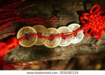A bunch of Chinese coins that attract good luck and wealth. Hieroglyphs mean attracting good luck and financial well-being. Royalty-Free Stock Photo #2036381126