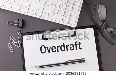Office paper sheet with text OVERDRAFT and keyboard. Business