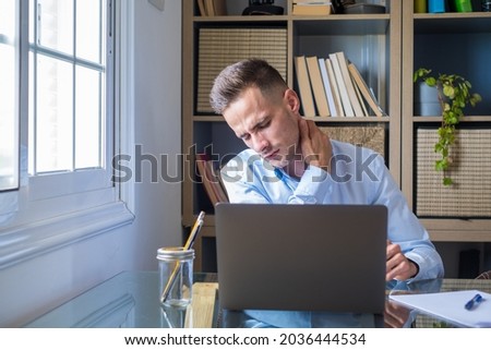 Pinched nerves, tensed sore muscles, fibromyalgia ache due sedentary lifestyle and incorrect posture concept. Caucasian ethnicity frowning man sitting at desk in front of laptop, touch neck feels pain Royalty-Free Stock Photo #2036444534