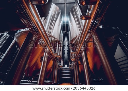 Rows of steel tanks for beer fermentation and maturation in a craft brewery Royalty-Free Stock Photo #2036445026