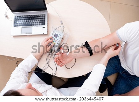 Patient nerves testing using electromyography at medical center Royalty-Free Stock Photo #2036445407