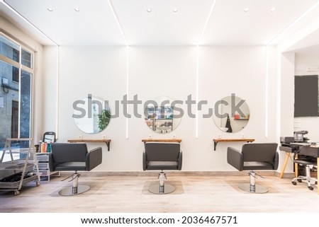 Modern bright beauty salon. Hair salon interior business with black chairs, round mirrors and neon lights. Royalty-Free Stock Photo #2036467571